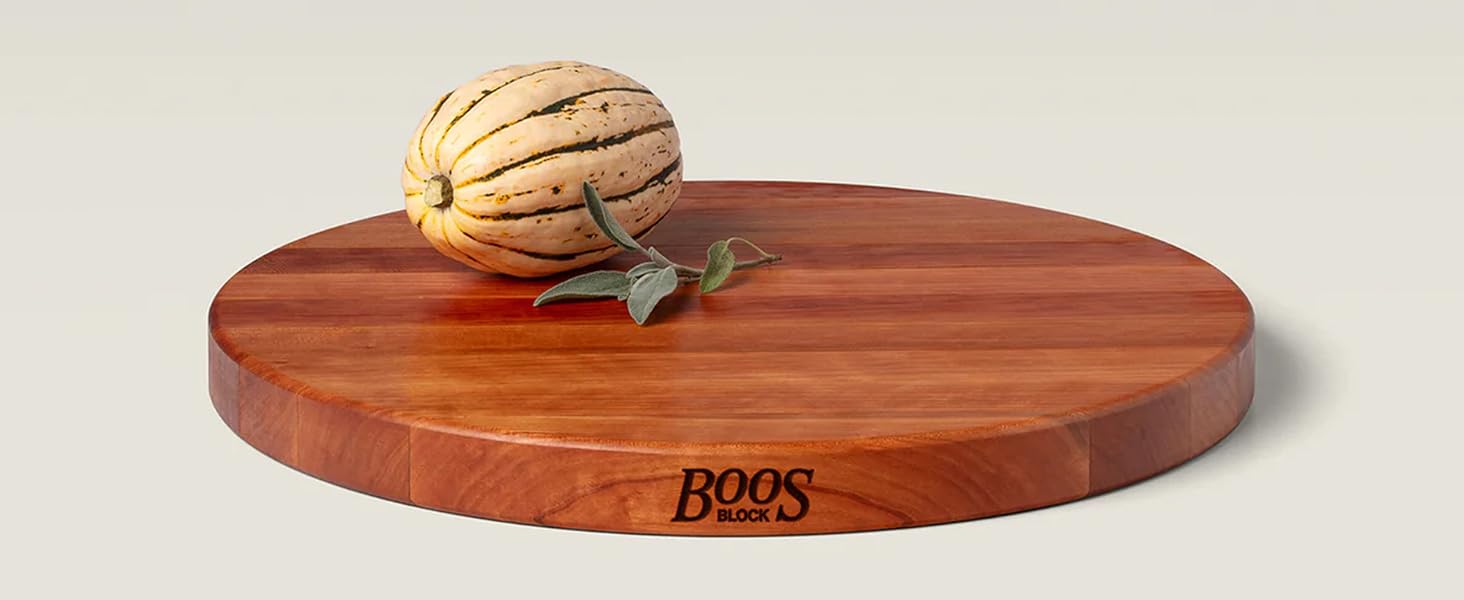 Round maple wood cutting board w/ a fruit on beige background.