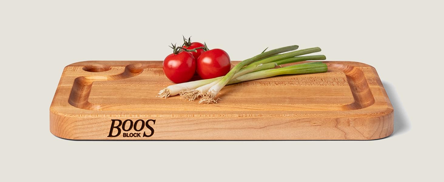 Wood cutting board with fresh vegetables placed on top, showcasing smooth finish and rich grain.