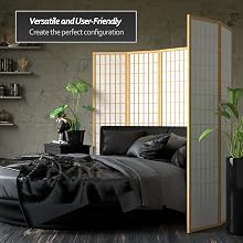 A natural wood shoji screen wraps around an elegant bed covered in black satin sheets