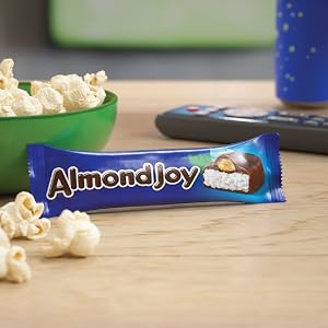 A full size Almond Joy candy bar next to a bowl of popcorn ready for movie night