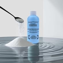 isonic white ultrasonic denture retainer cleaning bottle with crystal powder falling in a heap
