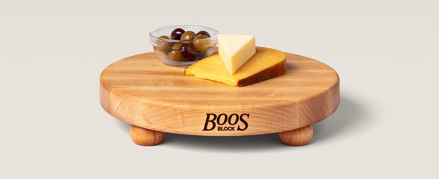 A cheese and olives on a wooden board on light background.