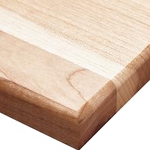 Close-up of light-colored wooden board or panel with rounded edge detail, showing natural wood grain texture.