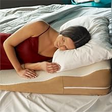 Woman sleeps on contoured bed wedge pillow
