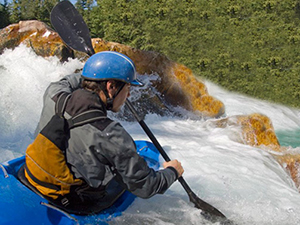 Man kayaking and using Avantree Cyclone speaker to listen to music.