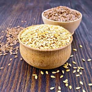 Golden and brown flax seeds in wooden bowls