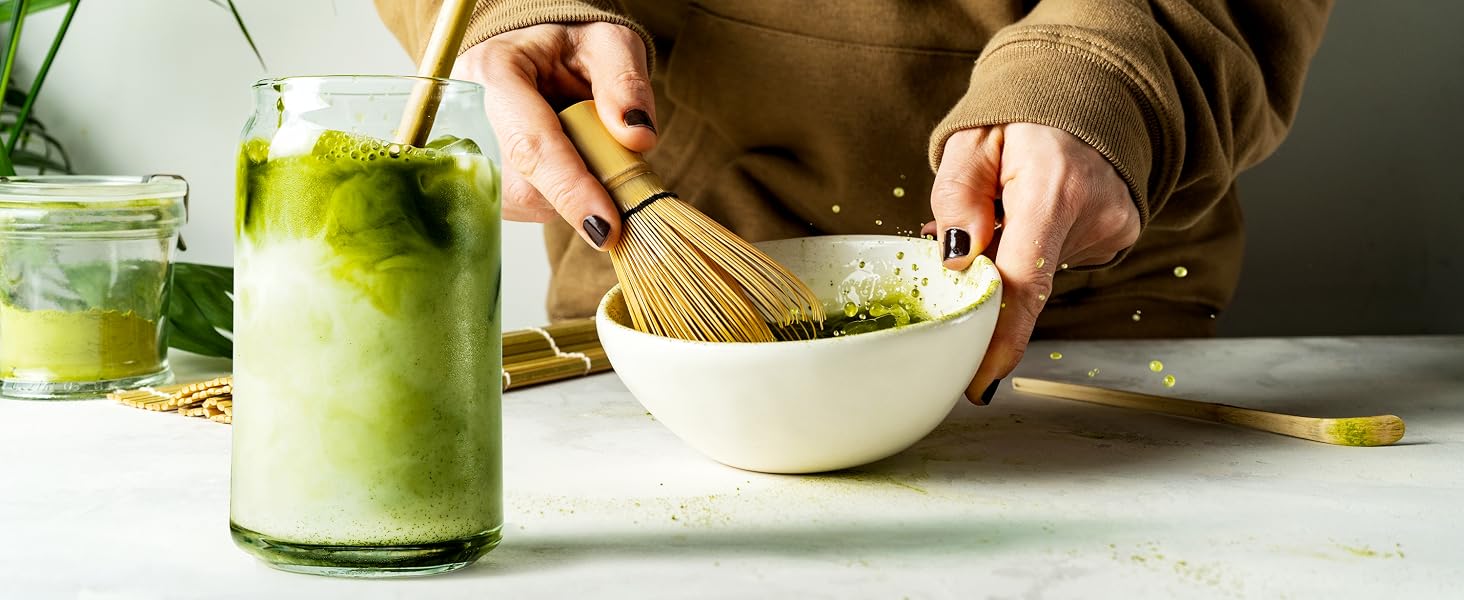 woman mixing ingredients for cna shaped drinking glass with straw and canister and bamboo on table