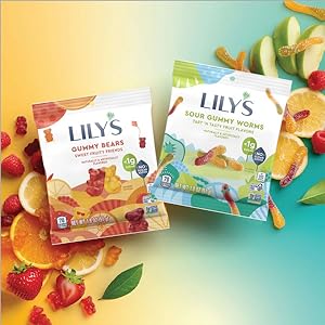 Bags of Lily's gummy bears and Lily's sour gummy worms on a background of sliced fruit