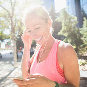 Woman with headphones in selecting a song before a run
