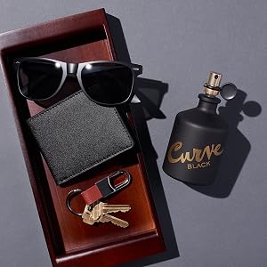 Curve Black for Men cologne with a tray filled with sunglasses, a wallet and keys