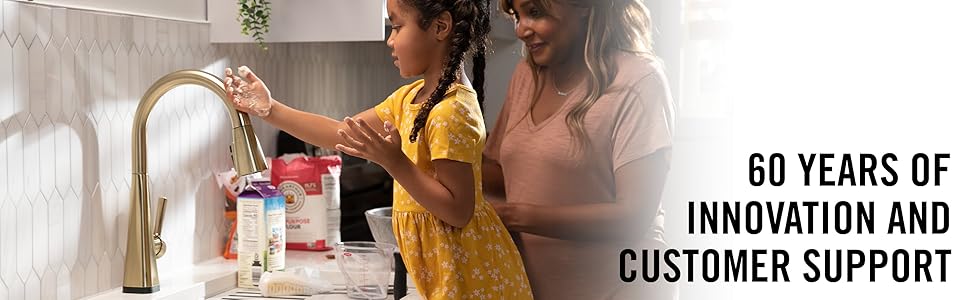image of a mother and daughter at the sink with daughter touching the faucet on