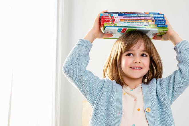 Kind mit B&uuml;cherstapel auf dem Kopf