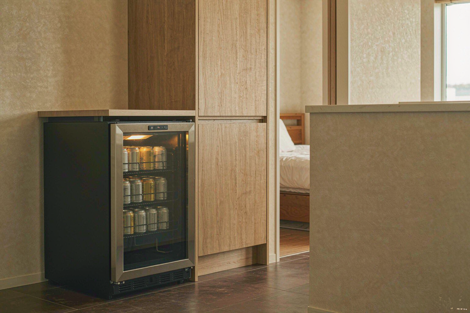 Glass-door beverage cooler in a bright kitchen