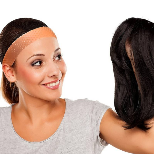 Hand holding transparent and light brown silicone grip wig bands with non-slip dotted texture