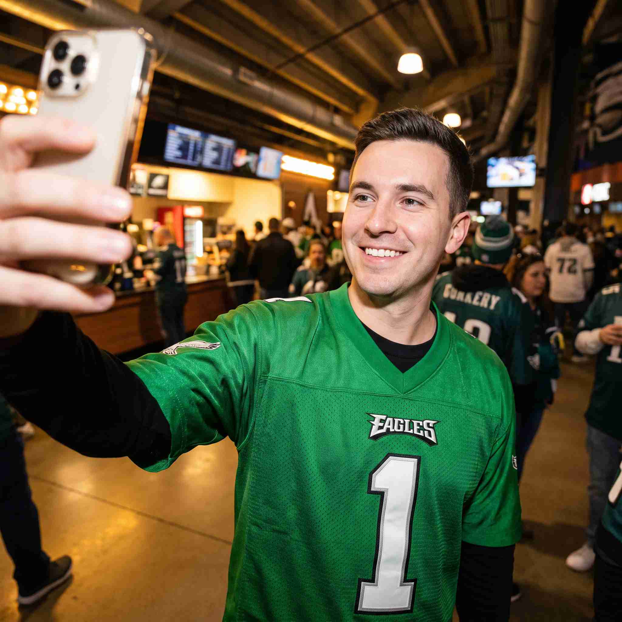 Football fan wearing Kelly green stitched jersey snapshot at game day concourse