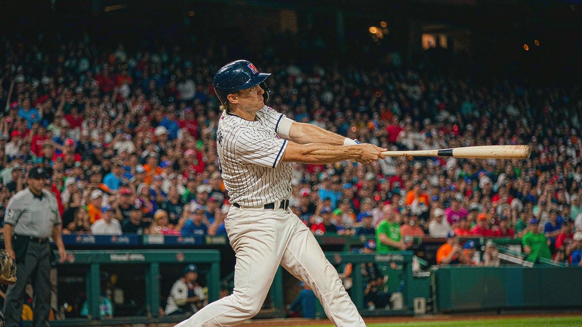 Major League Baseball night game with a batter mid-swing under stadium floodlights