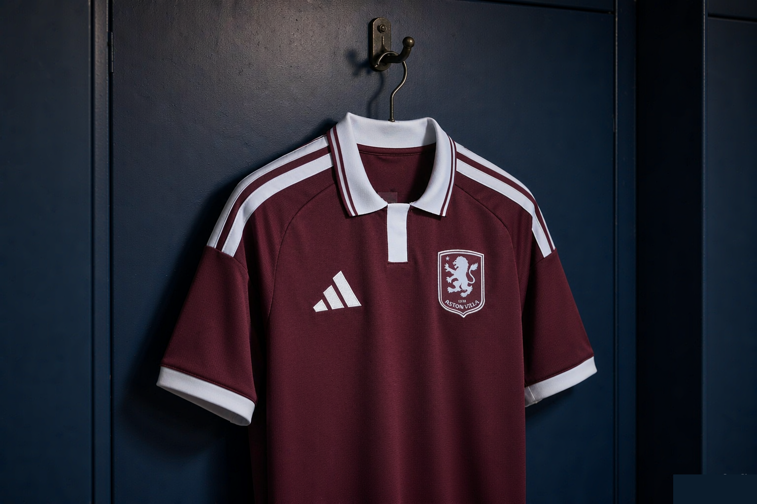 Aston Villa 2026/27 home jersey in claret and blue hanging in a dark locker room, editorial product photograph