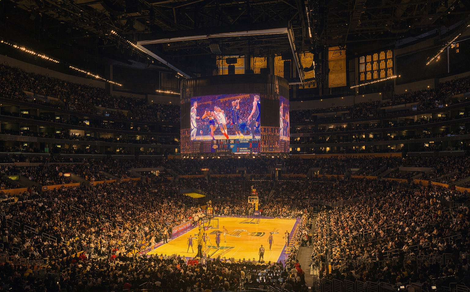 A packed basketball arena under the lights on opening night