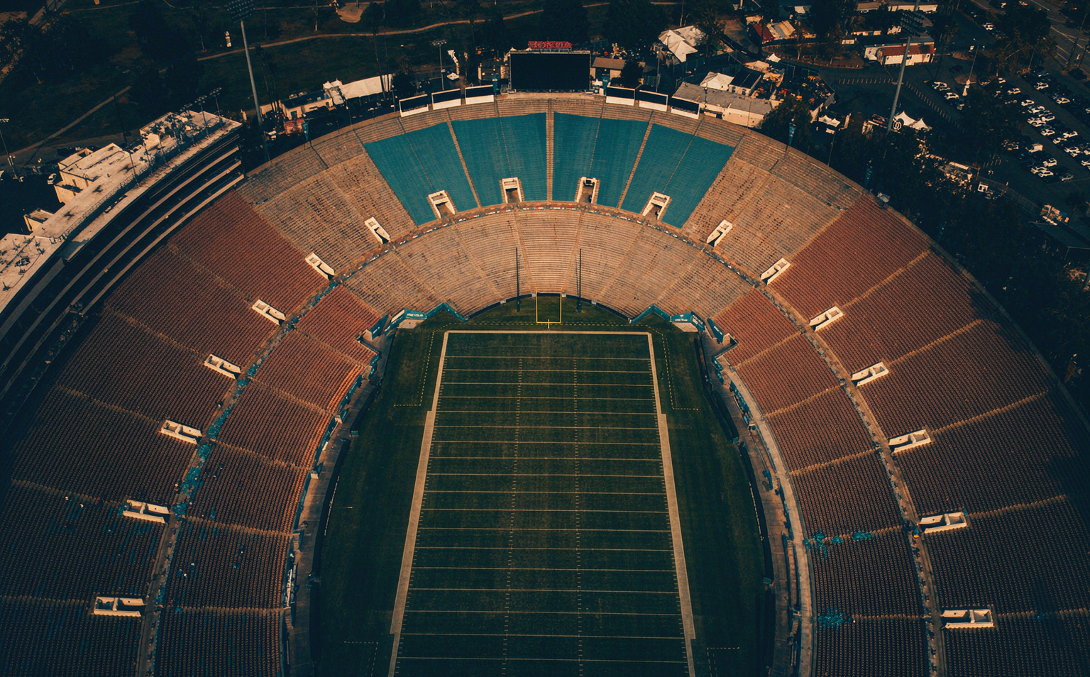 Aerial night view of a packed American football stadium under floodlights
