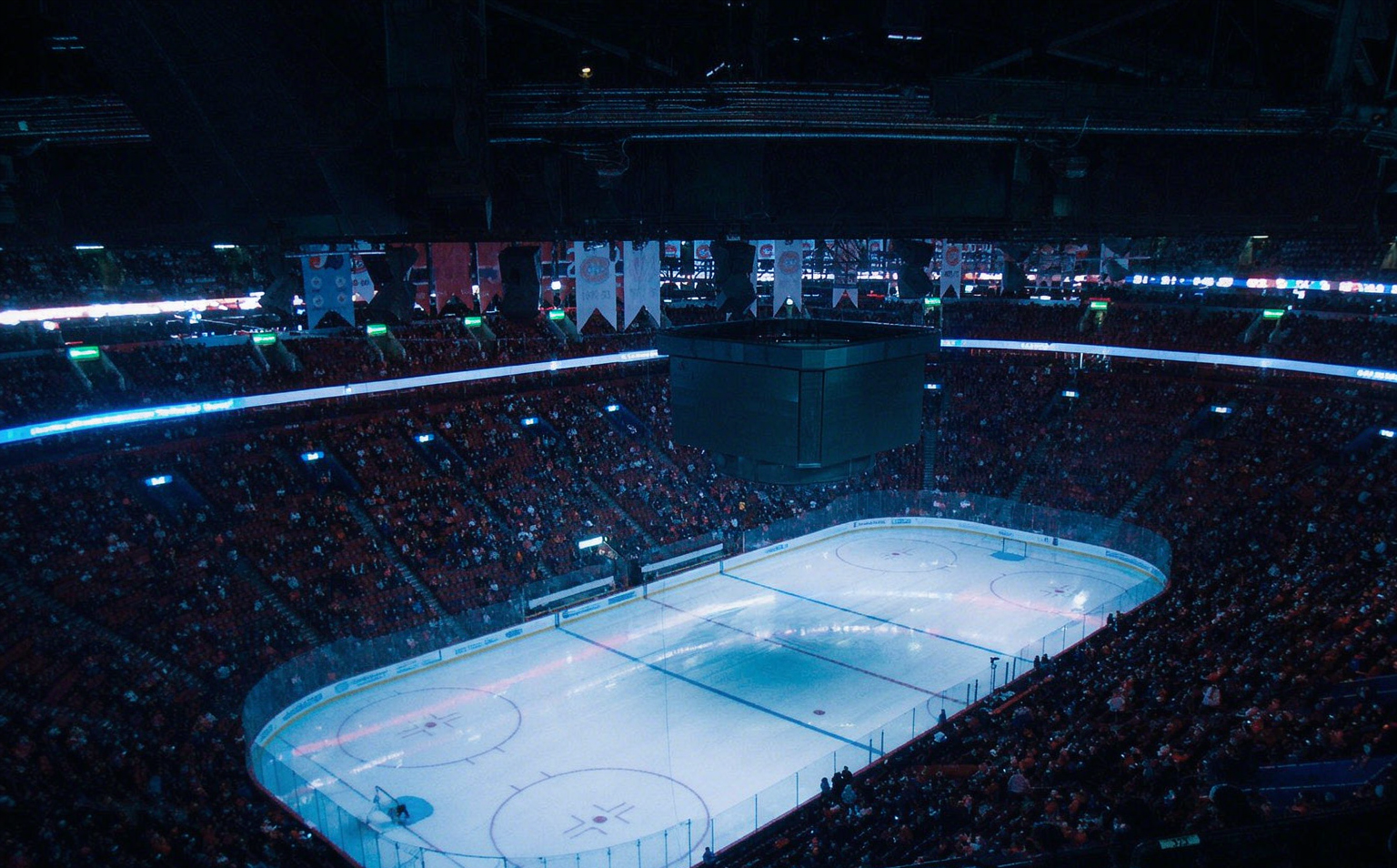 A packed hockey arena under the lights on opening night