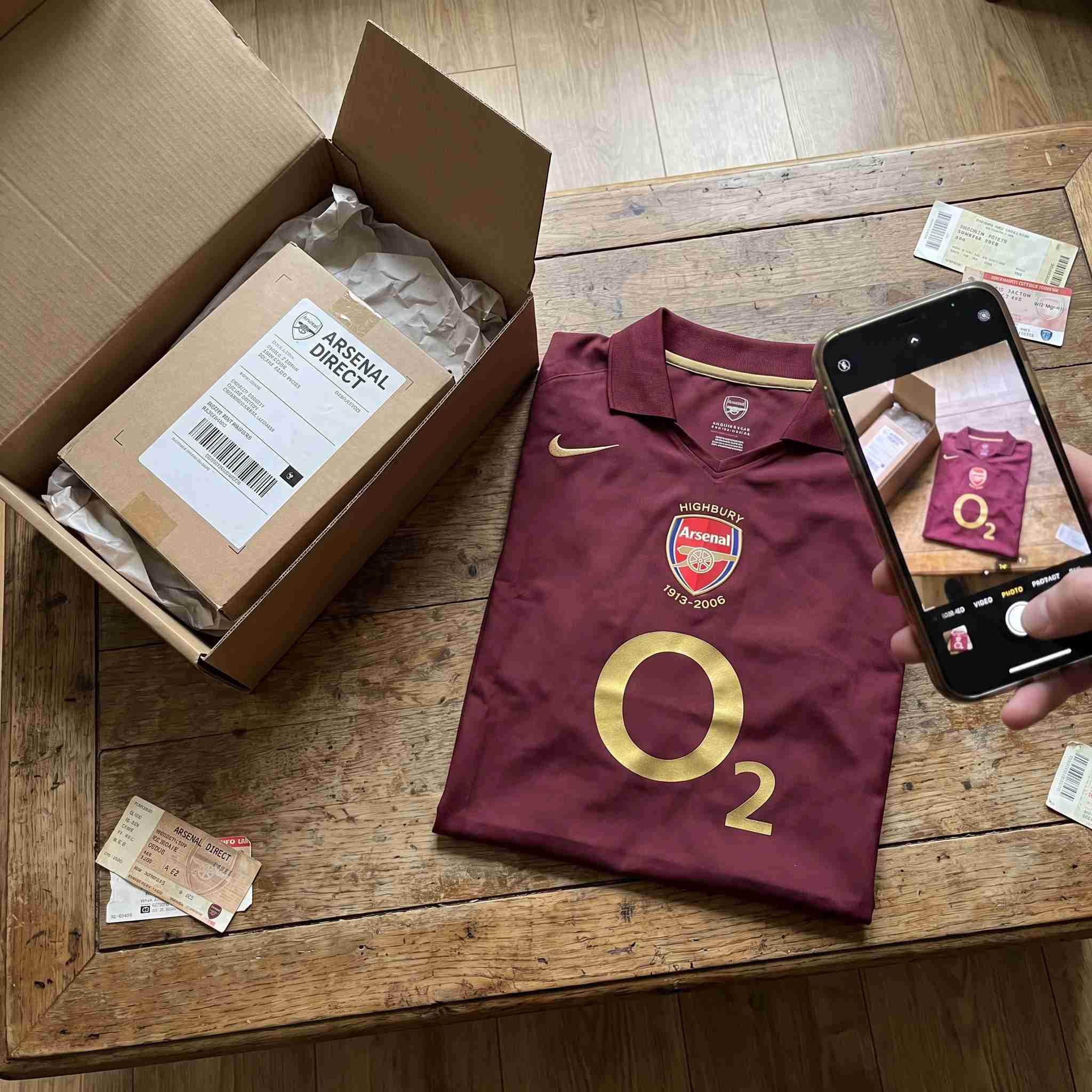 Maroon vintage commemorative soccer kit unboxing with shipping bag and tags on table