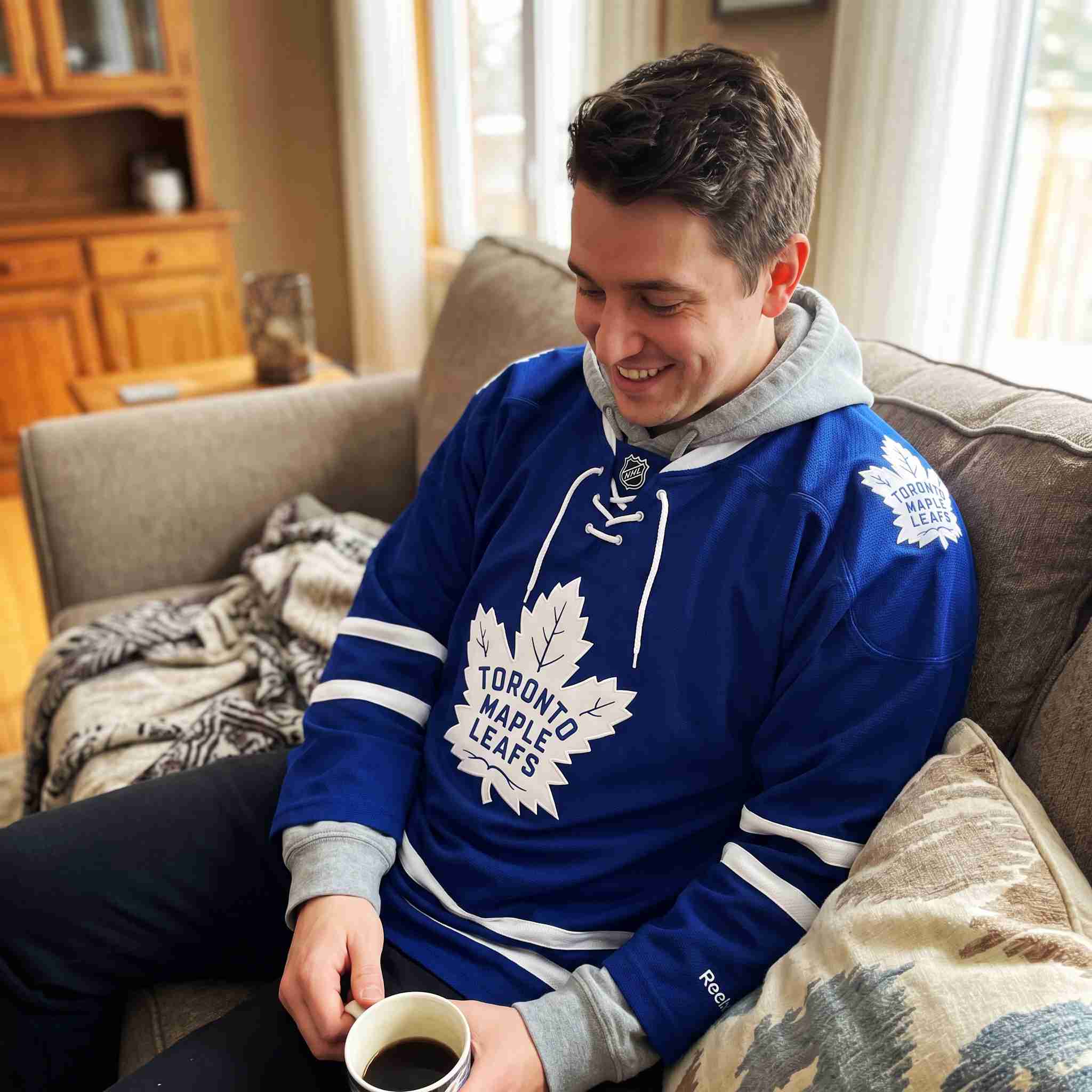 Customer holding and wearing royal blue stitched ice hockey sweater jersey