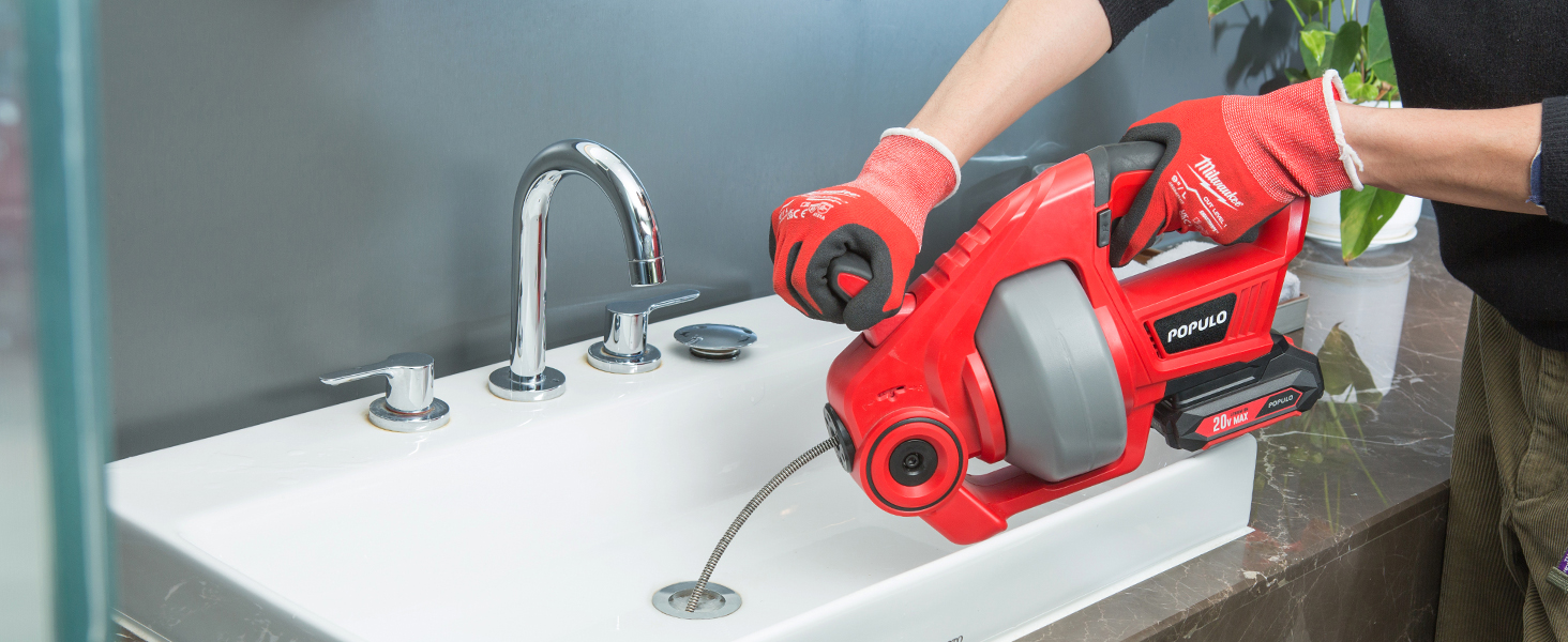 Cordless drain auger clearing a sink