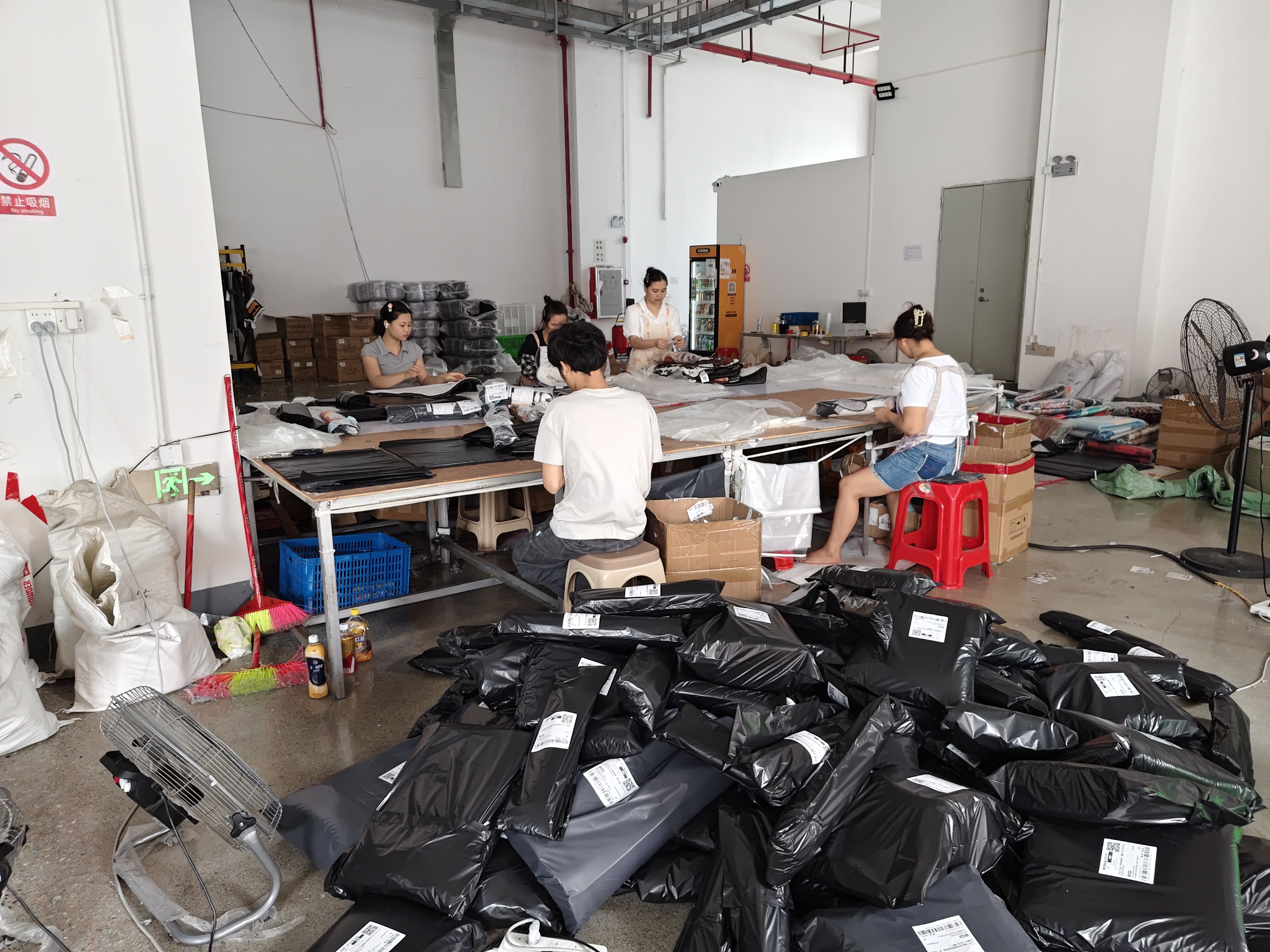 Team members pack labeled orders in our workshop for wholesale fulfillment and blind dropshipping shipments.
