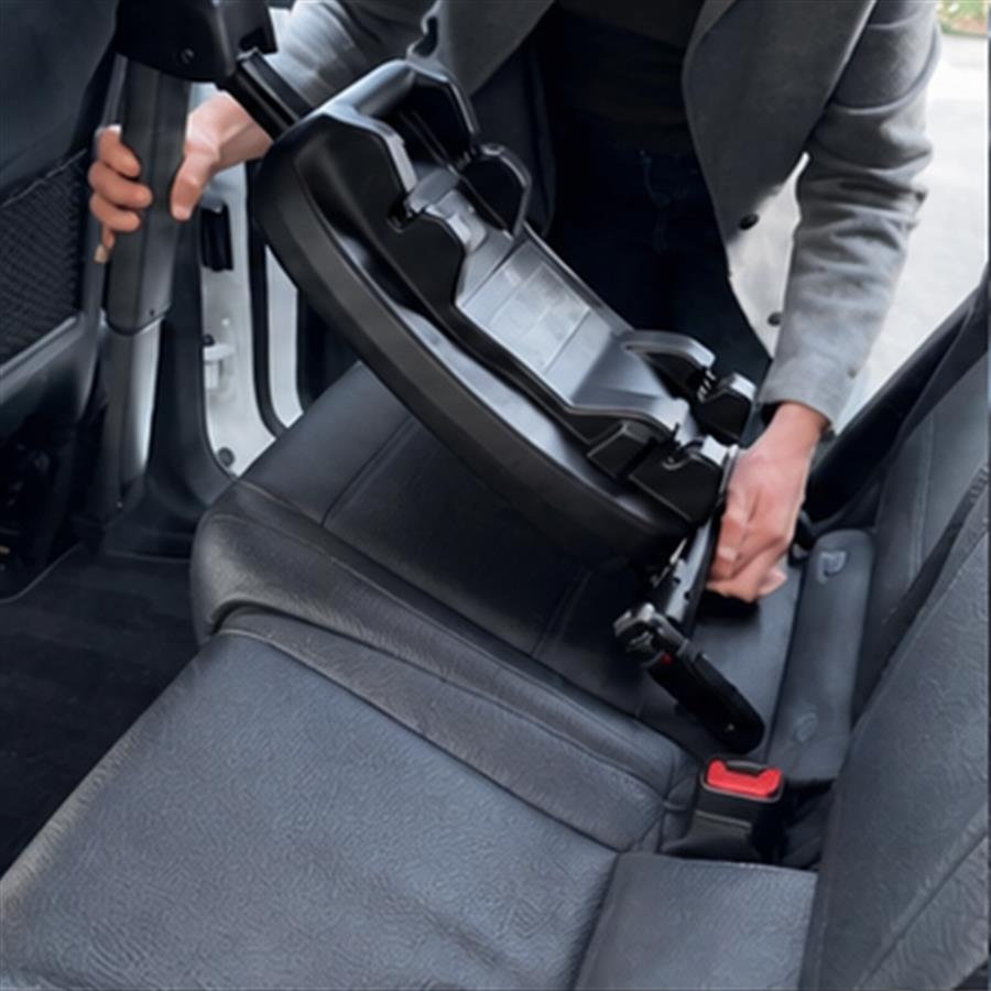 Owner installing the vehicle docking base across a rear car seat