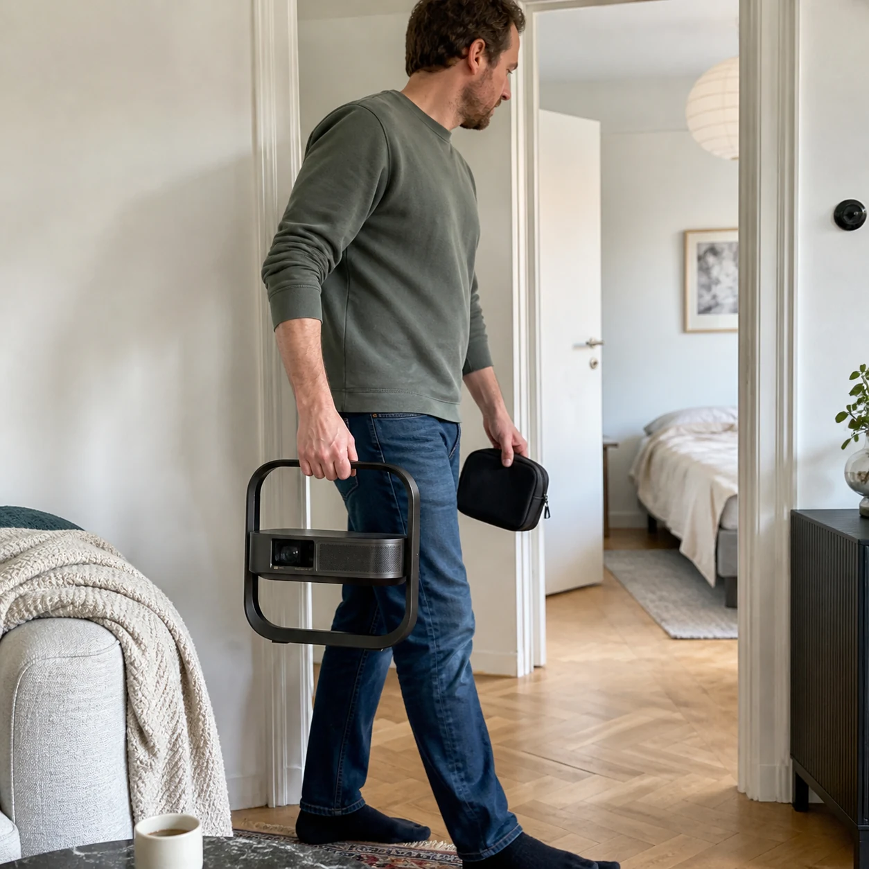 Person carrying the projector by its integrated frame while holding the remote and power lead in a small pouch