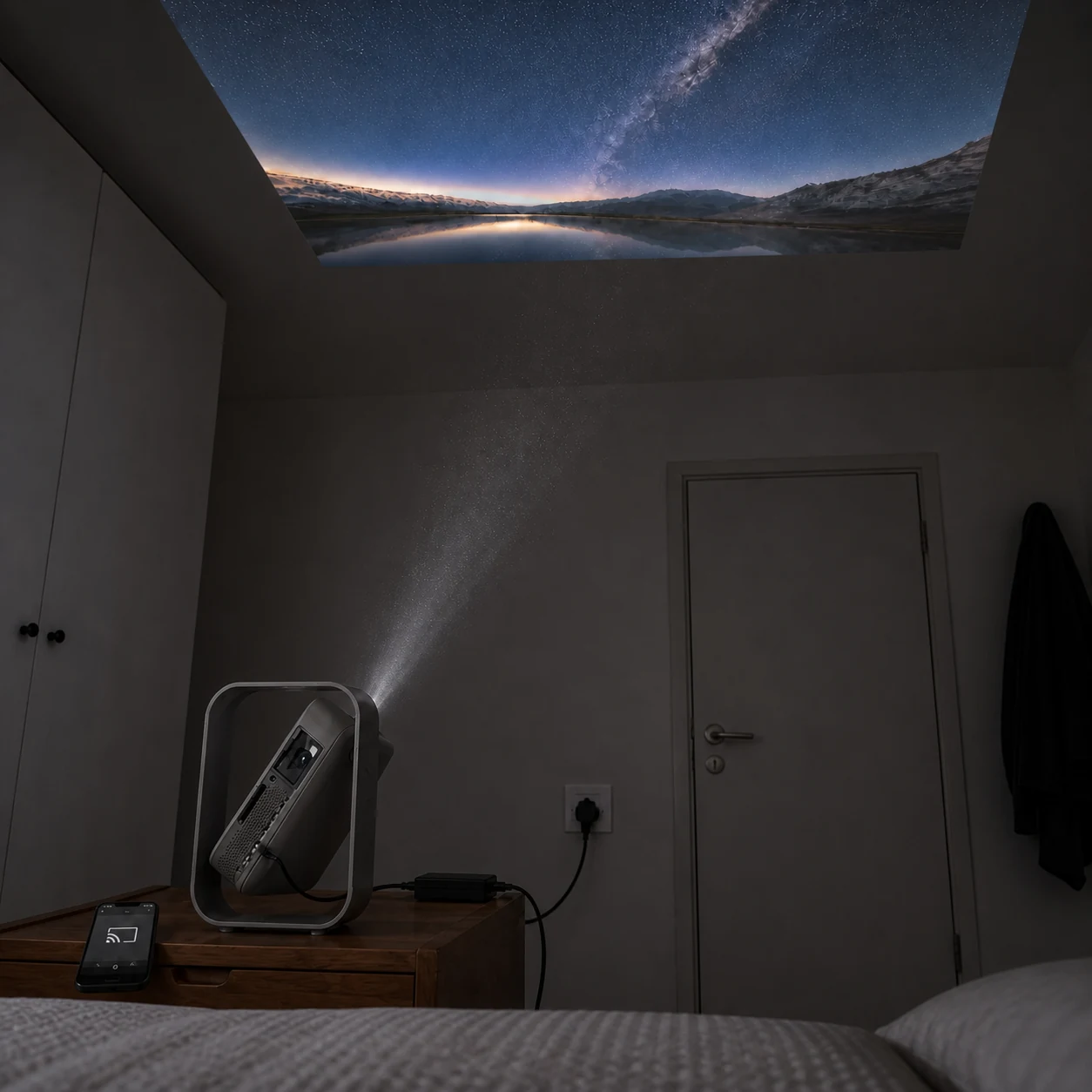 Bedside projector tilted upward with the optical glass, aligned light path, ceiling image, adapter and wall outlet visible