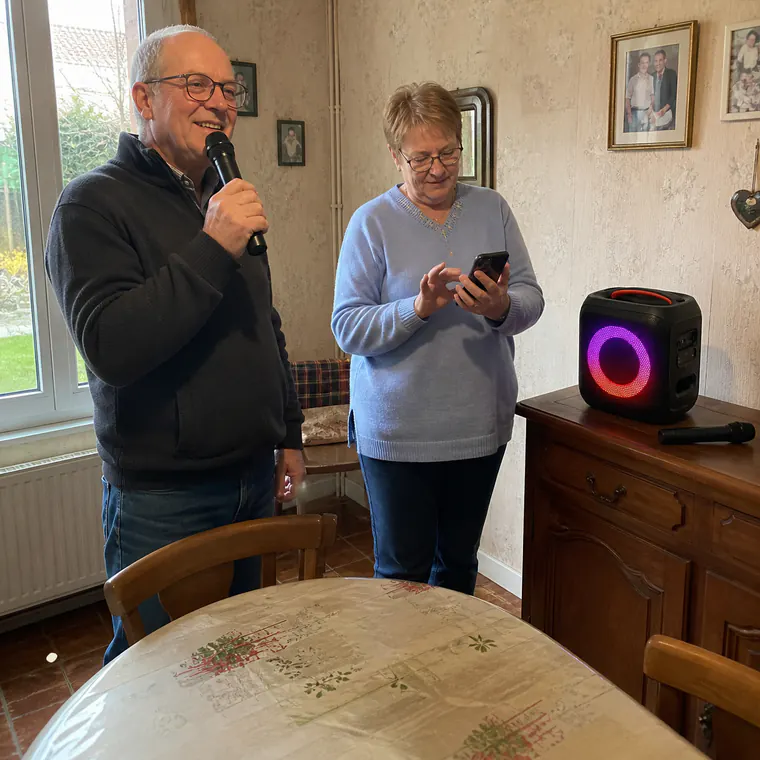 Older couple setting up karaoke in a French dining room