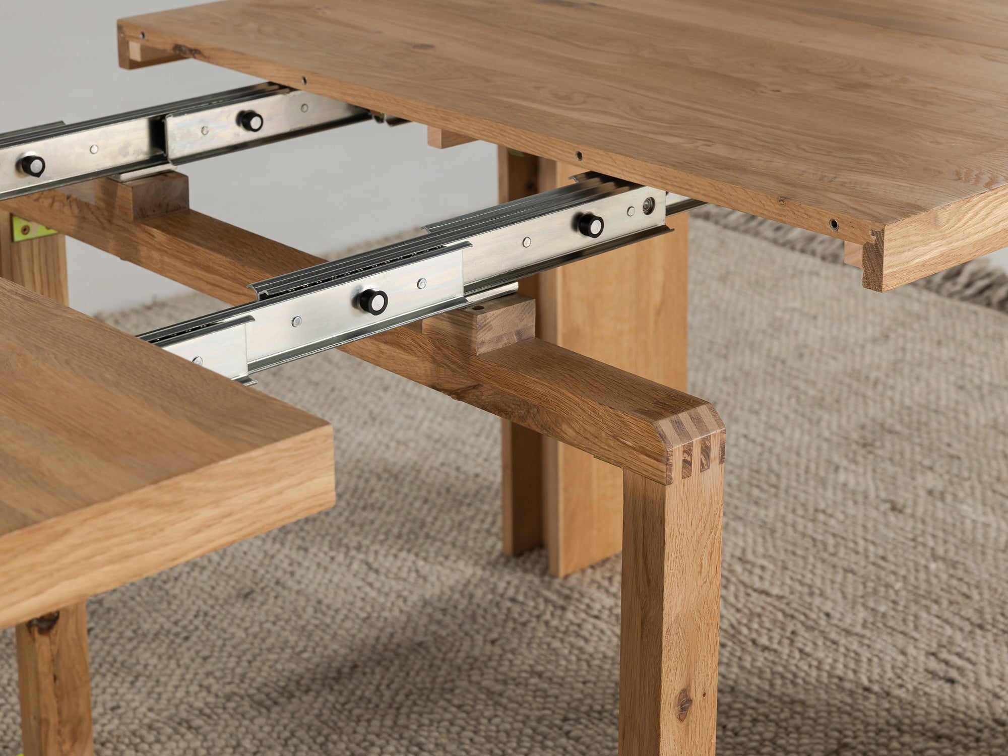 Telescopic metal rail system inside the extendable dining table