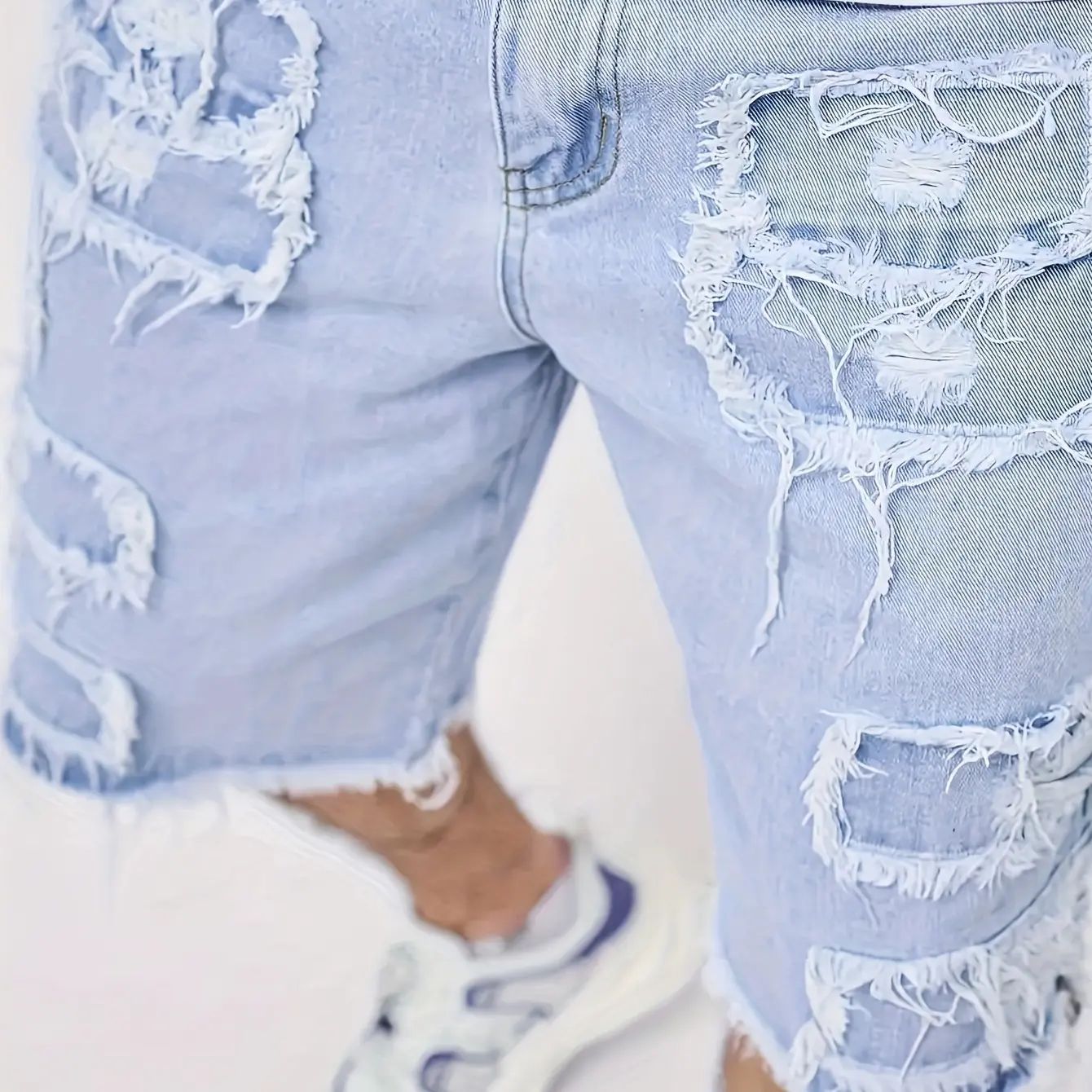 Distressed raw-edge denim shorts with slight stretch; pants without a drawstring