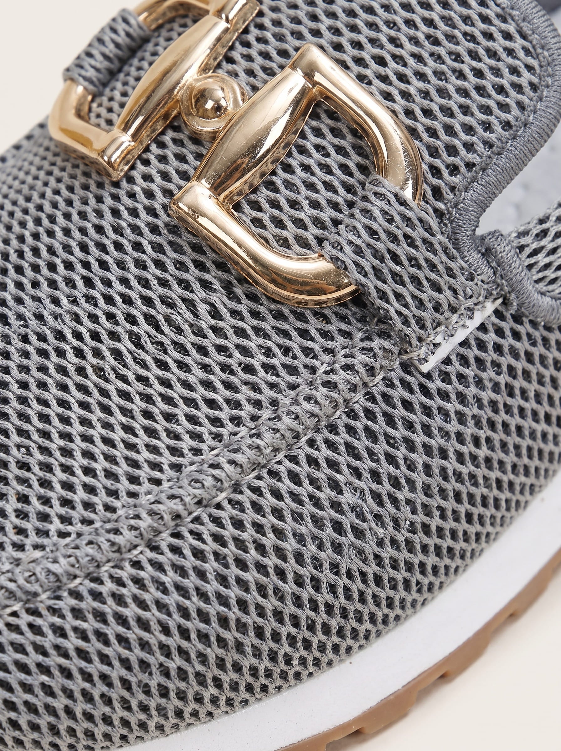 Close-up of silver gray mesh and gold-tone buckle