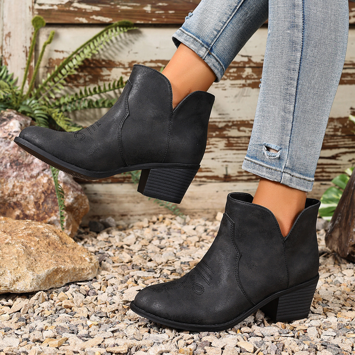 Black embroidered western ankle boots worn with jeans