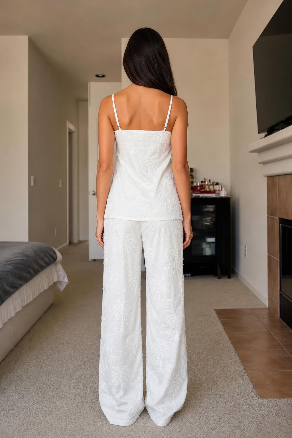 Back view of woman in white palm embroidered lounge set