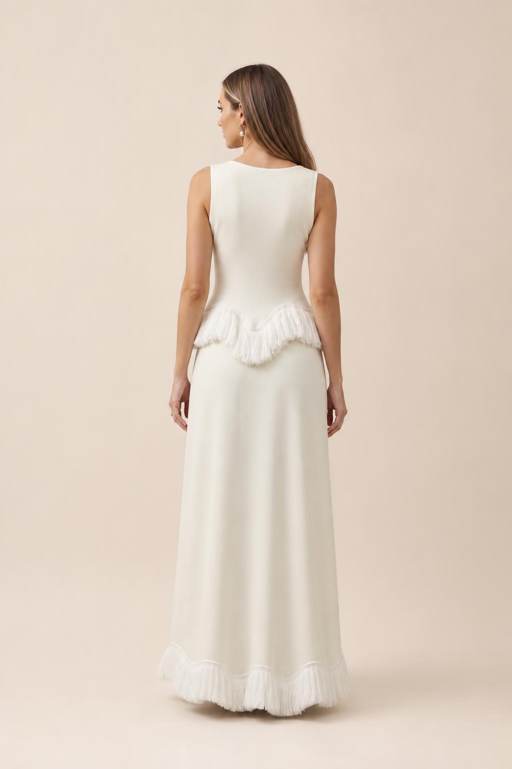 Back view of white fringed peplum maxi dress against neutral studio backdrop