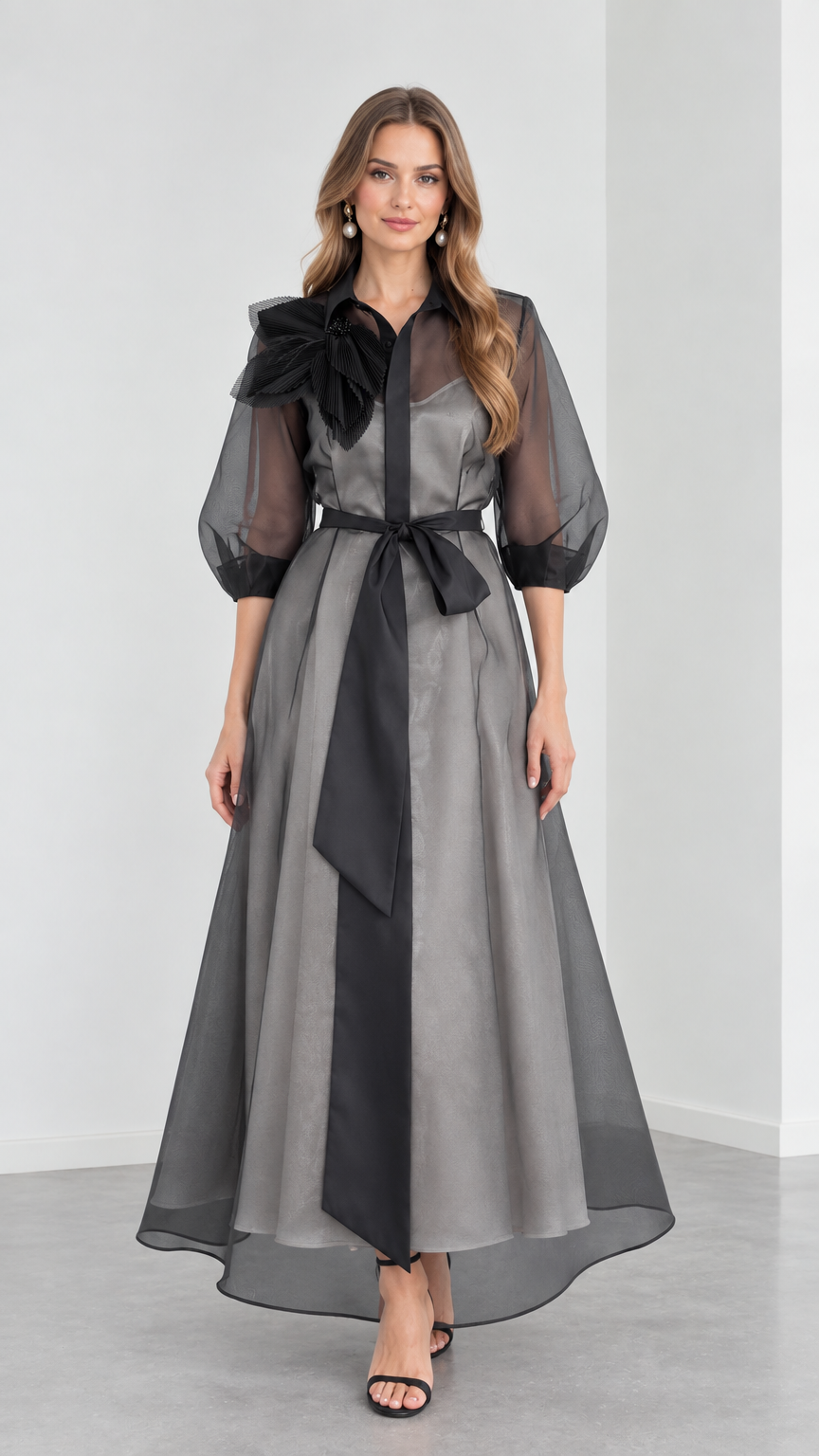 Full front view of model wearing Charcoal Grey organza collared maxi shirt dress with black sash and 3D floral shoulder detail