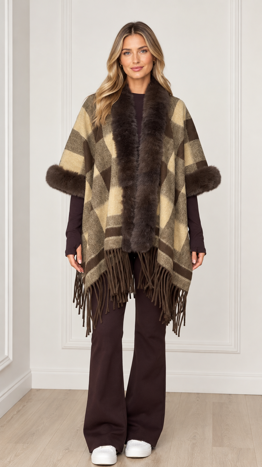 Woman wearing olive khaki plaid poncho with faux fur collar and fringe hem - front view