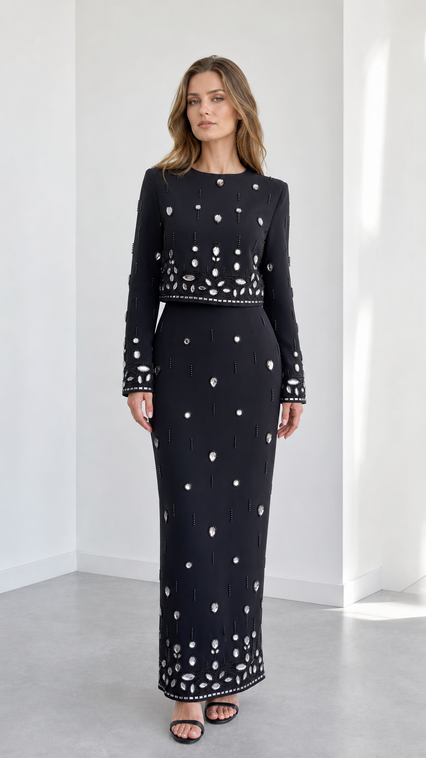 Front view of black long sleeve embellished crop top and column maxi skirt two-piece set
