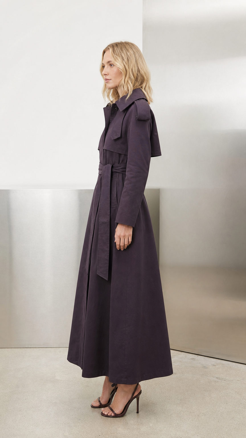 Side profile view of deep purple maxi trench coat showing structured length and lapel