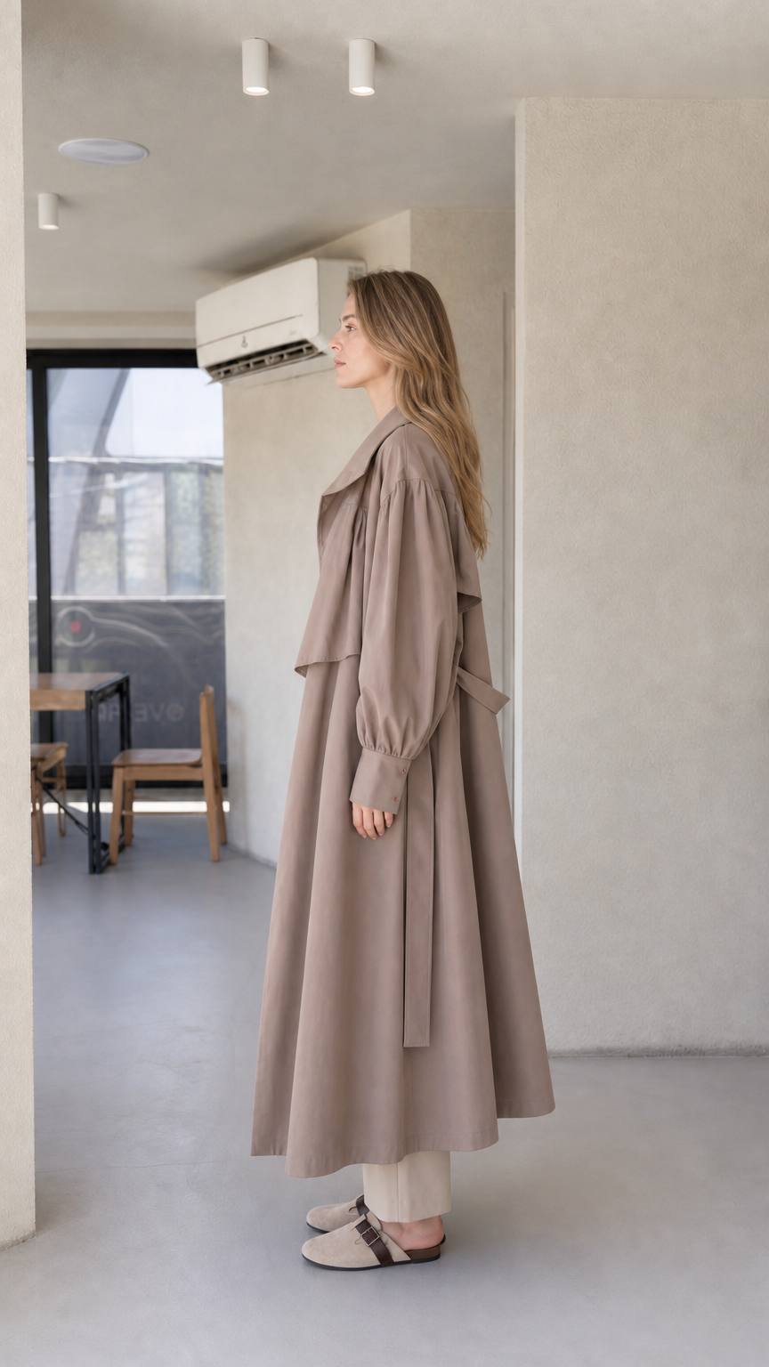 Side profile of model wearing the taupe brown longline maxi trench coat
