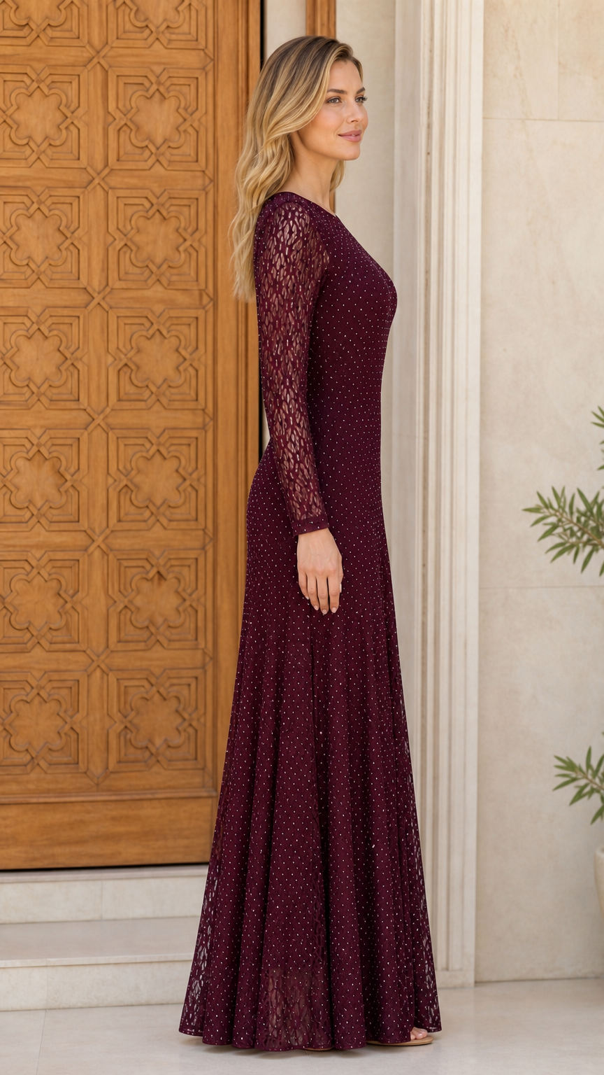 Side profile view of burgundy lace long sleeve evening gown