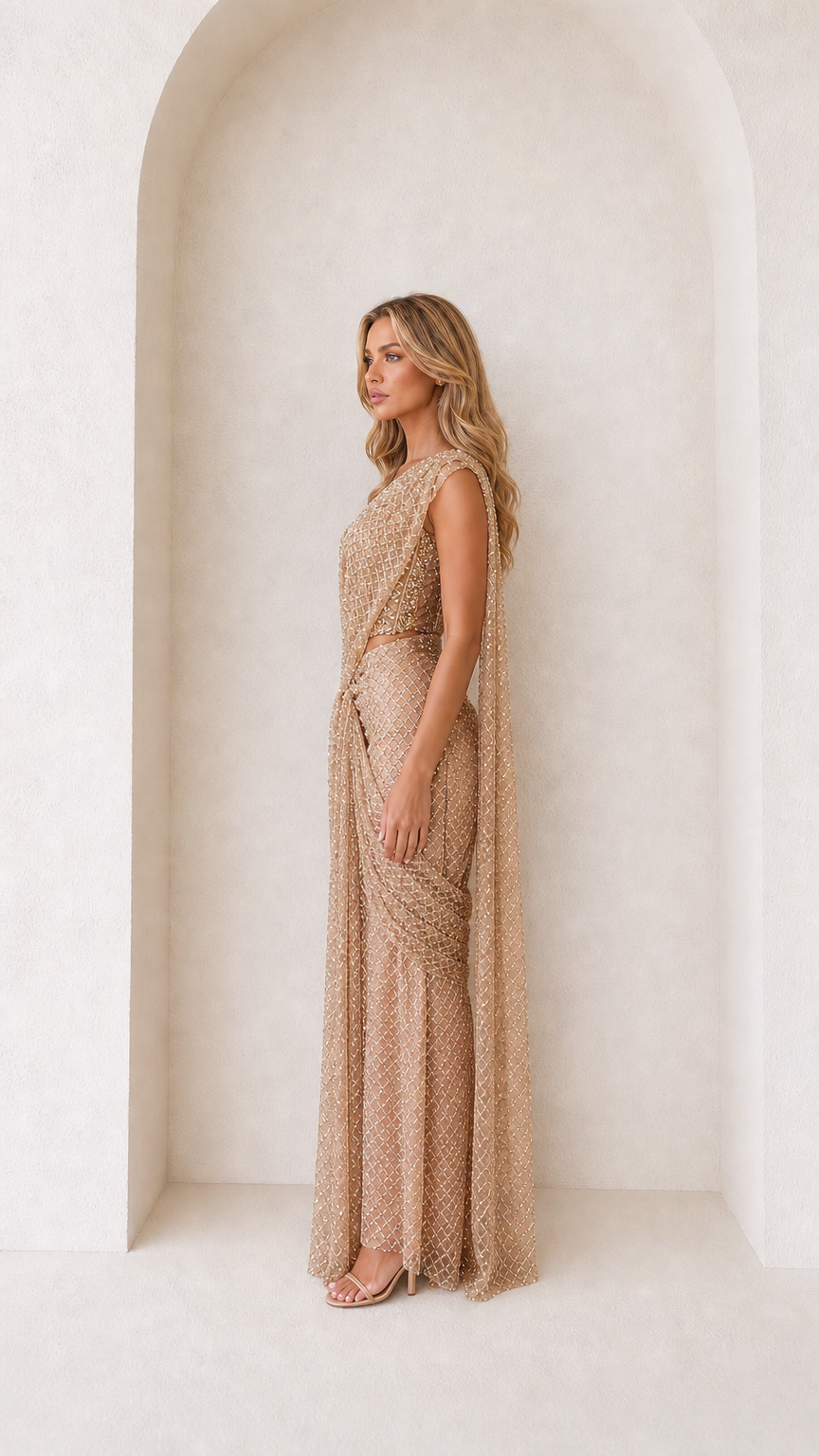 Side angle of woman in Champagne Gold draped sequin maxi gown
