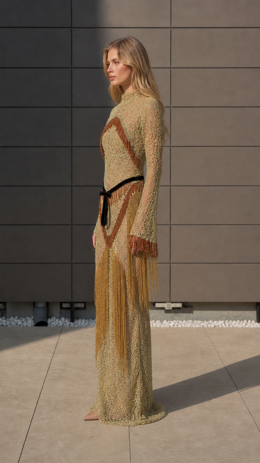 Side profile of model in gold fringe maxi dress