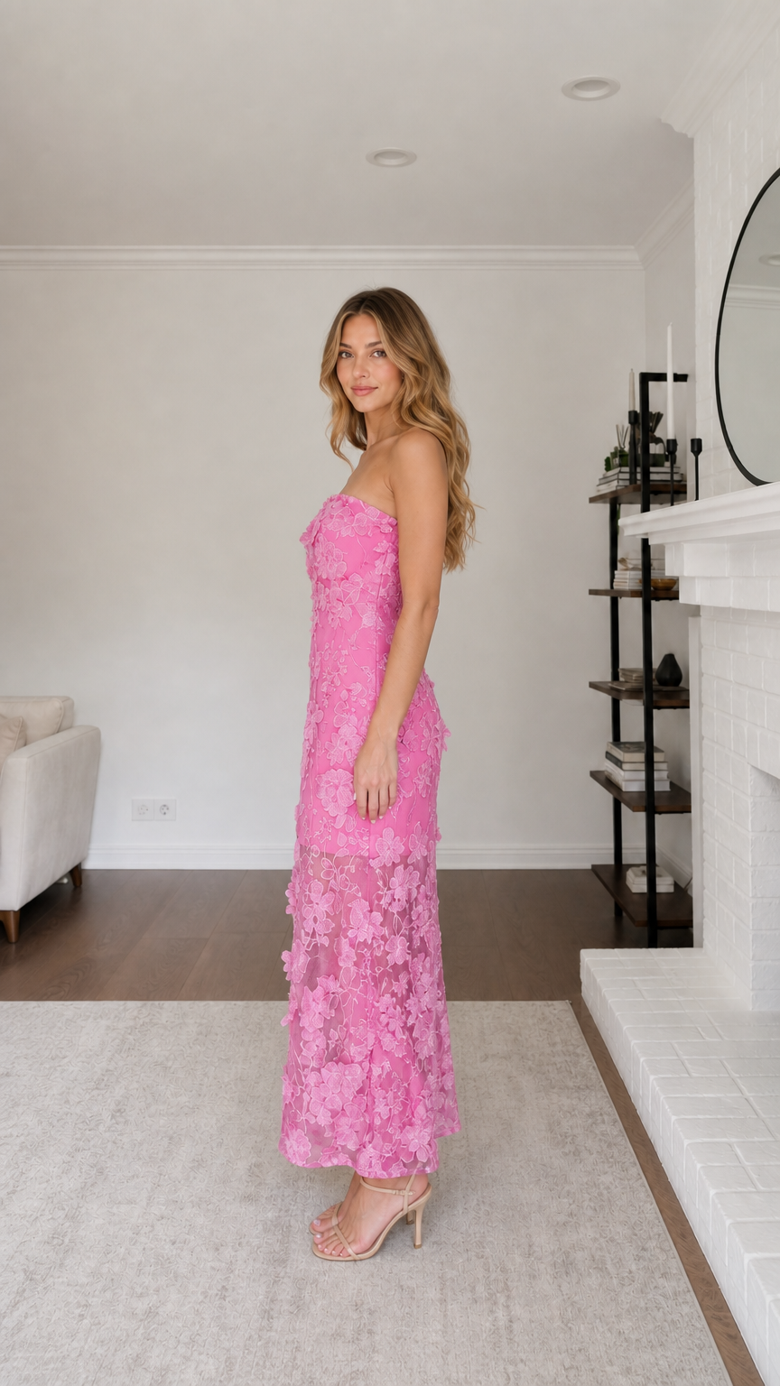 Side profile view of model in pink strapless maxi dress