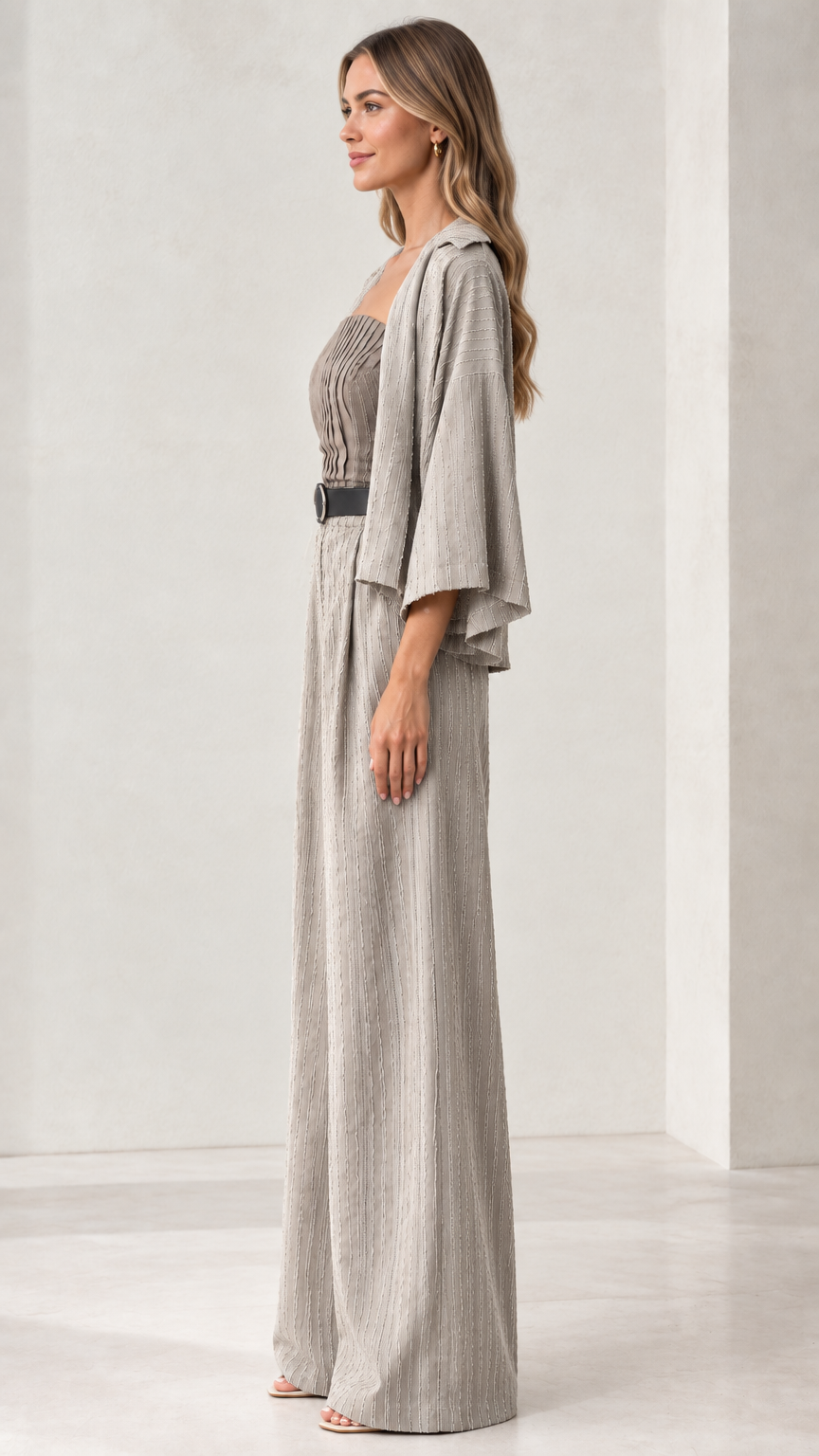 Side profile of woman wearing light grey pleated wide-leg jumpsuit set