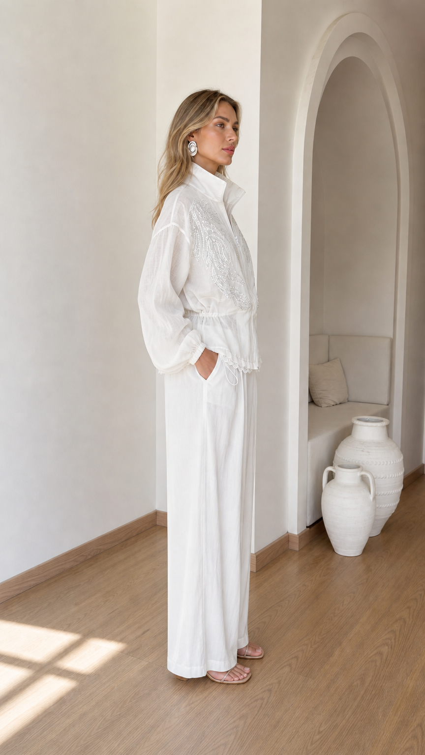 Side view of woman wearing white embroidered two-piece pant set