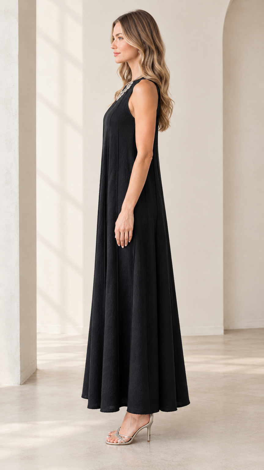 Side profile view of woman wearing black flowy sleeveless maxi dress
